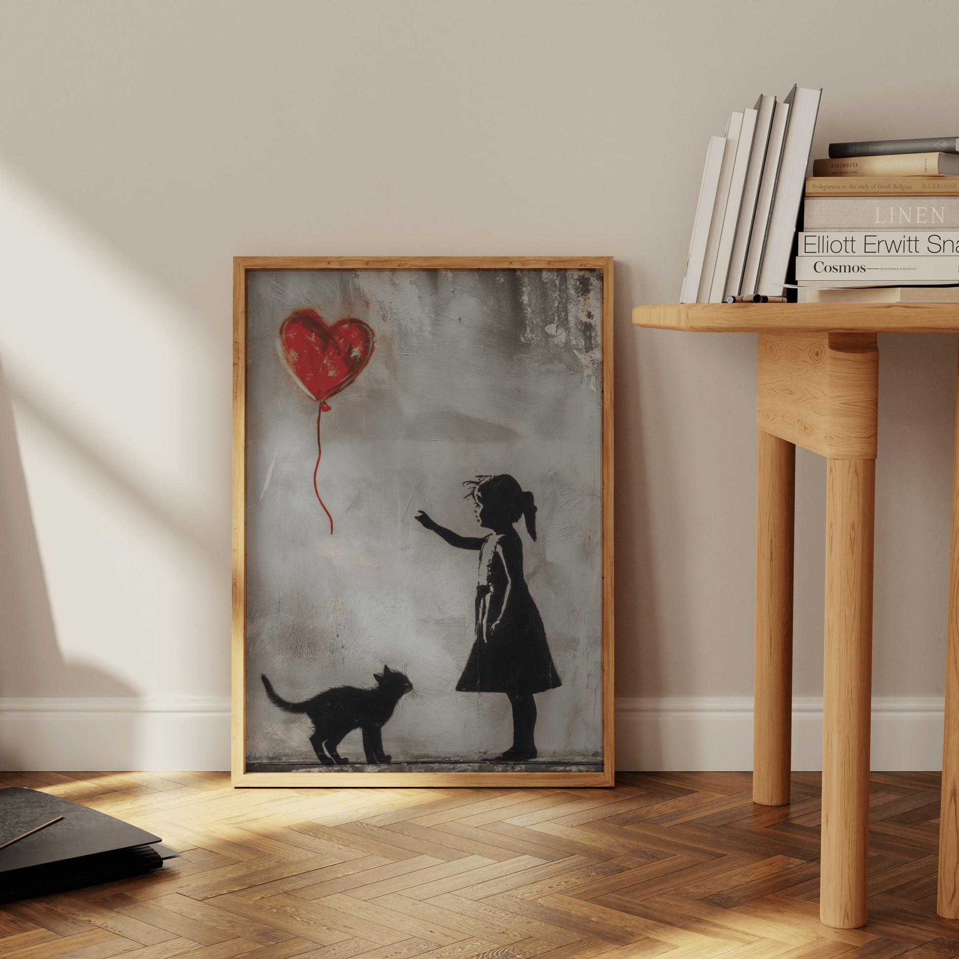 Painting of a little girl with her cat, reaching out to the red heart-shaped balloon, leaning against the office wall. 